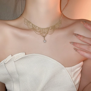Detail of 24K gold-plated lace choker featuring a white teardrop pearl on woman neck