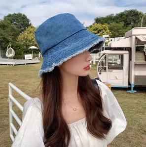 Détail des bords effilochés d'un chapeau bob en denim bleu avec protection solaire d'été