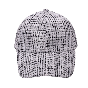Detail of black and white tweed baseball cap with textured fabric and classic curved brim