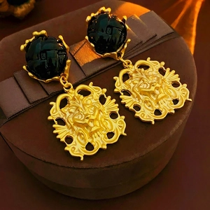 Vintage golden lion head drop earrings featuring black round cabochon stones