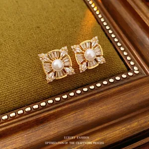 Elegant square pearl stud earrings with zircon halo on vintage green fabric background