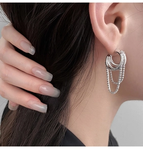 Close-up of a silver multi-layer hoop earring featuring sparkling cubic zirconia chain tassels