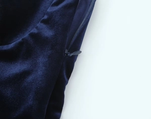 Detailed macro view of dark blue velvet fabric texture and smooth invisible zipper closure