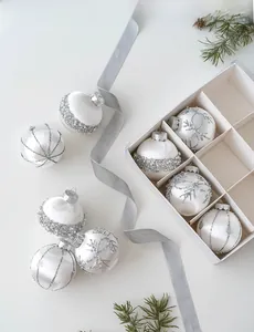 Detailed view of luxury pearl white and silver Christmas ornaments with glitter patterns