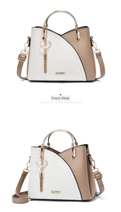 Detail of color-blocked tote with gold circular handle, ZZMY logo, and pearl heart charm