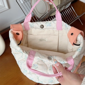 Detail of the internal pocket and magnetic snap closure on the floral quilted tote bag