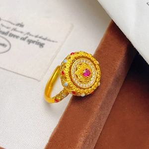 Gros plan sur une bague tournante vintage dorée avec pierre rouge et détails filigranes