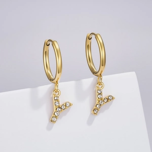 Detail of a golden hoop earring featuring a sparkling crystal-studded letter Y pendant