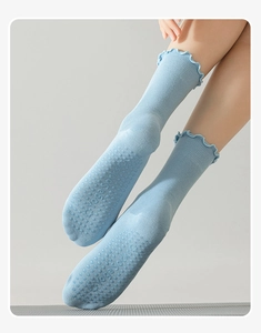 Detail of light blue yoga socks showing ruffled cuffs and non-slip silicone grip patterns