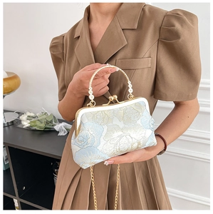 Close-up of embroidered floral cheongsam handbag with gold frame and beaded handle