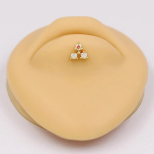 Macro view of gold triangle piercing stud with three opal stones on silicone model
