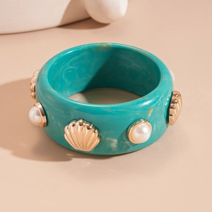 Detail of teal resin wide bangle with marble texture, golden shells and faux pearls