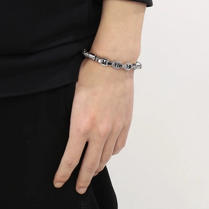 Close-up of silver-tone stainless steel anchor chain bracelet worn on male wrist