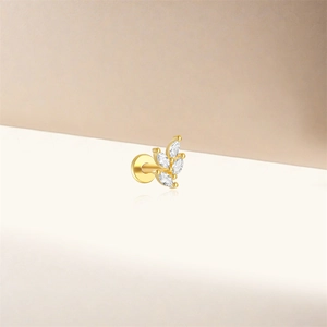 Détail de clous d'oreilles en forme de feuille dorée avec cinq pierres marquises