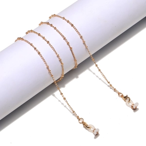 Detailed view of golden metal eyewear chain with white silicone anti-slip loops