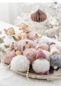 Macro shot of plush Christmas angel ornaments with fluffy pom-poms and resin faces