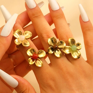 Golden flower rings set with colorful beads shown on hands for vintage fashion style