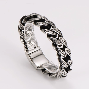 Detail of vintage silver totem bracelet featuring engraved scripts and a clasp closure