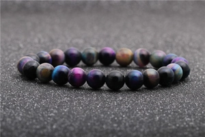 Macro detail of the beaded bracelet featuring polished black obsidian and starry sky stones