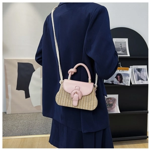 Detail of woven straw handbag with pink PU leather trim and matching rope strap