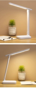 Adjustable white LED desk lamp casting warm light on a wooden table for eye protection