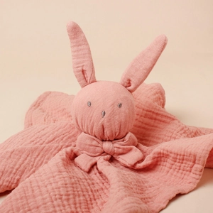 Close-up of pink muslin cotton baby security blanket with rabbit ears and bow