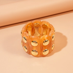 Detail of orange marble acrylic stretch bracelet with gold metallic accents and chic texture
