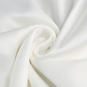 Détail du tissu satiné blanc avec une texture lisse et un drapé élégant pour robes