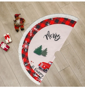 Detail of burlap Christmas tree skirt with red truck print and white tassel trim