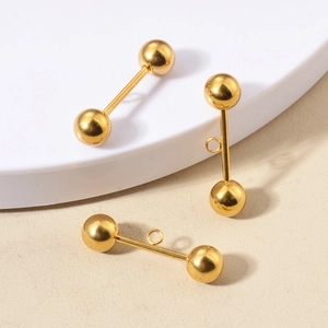Three gold stainless steel ball stud earrings with connector loops on a white podium