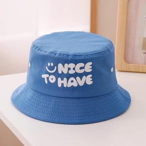 Détail du chapeau cloche bleu en coton avec texte NICE TO HAVE et motif de sourire