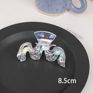 Detail showing 8.5cm iridescent laser hair claw clip with wavy design on a black disc