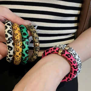 Close-up of stylish leopard print resin bracelets with gold beads and vibrant patterns