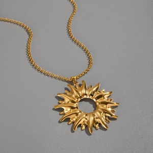 Detailed close-up of golden sun pendant necklace with hollow radial design