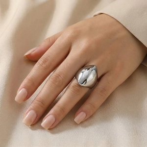 Polished silver stainless steel ring with an organic drop shape worn on finger