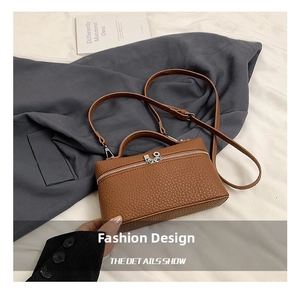 Close-up of brown litchi pattern leather bag with silver hardware and top handle