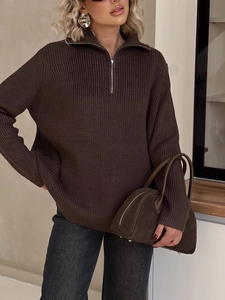 Detailed close-up of dark brown ribbed knit sweater featuring a half-zip neckline design