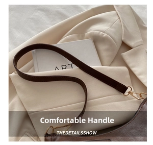 Close-up of the dark brown leather strap and high-quality gold metal buckle of the bag