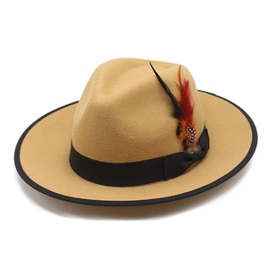 Close-up of khaki wool fedora hat featuring a black ribbon and decorative dotted feather