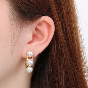 Detail showing vintage 18k gold plated C-shaped earrings with inlaid shell pearls