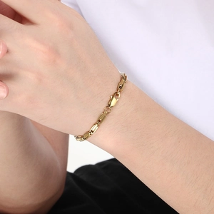 Close-up of golden stainless steel bamboo link bracelet on wrist with lobster clasp