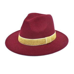 Detail of burgundy wool fedora hat featuring a sparkling gold glitter ribbon band