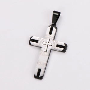 Detail of silver and black cross pendant with Greek key pattern and layered metal design