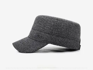 Detail view of the tweed flat top winter cap with vintage metal logo and thick texture