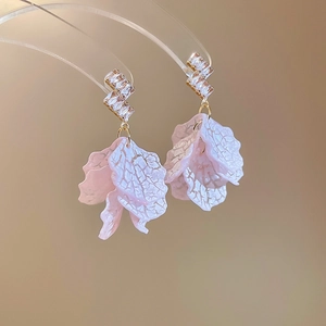 Close-up of pink shell flower petals with gold geometric studs and cubic zirconia accents