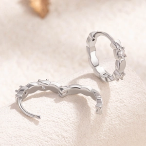 Elegant silver wave hoop earrings with clear cubic zirconia inlays for a sleek look