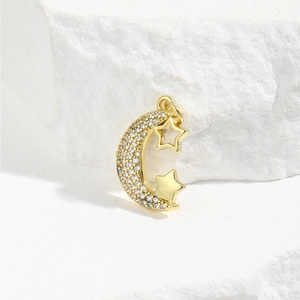 Macro detail of gold moon and star pendant with white cubic zirconia inlay on stone