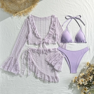 Flat lay detail of purple four-piece lace bikini set with matching cardigan and skirt