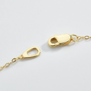 Macro shot of gold-plated S925 lobster clasp detail on minimalist silver bracelet