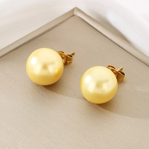 Close-up of golden spherical pearl stud earrings with butterfly backs on champagne silk